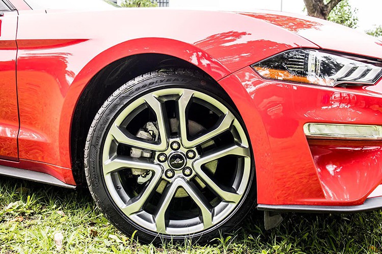 Ford Mustang bản kỷ niệm sử dụng bộ mâm 20 inch hợp kim màu titan 5 chấu kép thiết kế hình chữ V. Không có tích hợp xi-nhan sonh gương chiếu hậu của mẫu xe thể thao 2 cửa này vẫn có tính năng cảnh báo điểm mù. Cụm đèn hậu gồm 3 dải LED đi lèm cặp ống xả đôi với đèn phản quang kết hợp hệ thống cản sau thiết kế góc cạnh càng làm nổi bật phần đuôi xe. Ford Mustang bản kỷ niệm